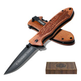 Wooden folding knife with engraved text on a white background