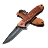 Wooden folding knife with engraved text on a white background