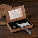 Knife with American flag design in a wooden box on a wooden surface