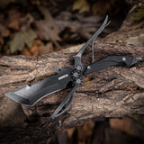A black multi-functional fixed blade scissor knife with sheath, displayed on a wooden surface.