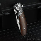 A folded pocket knife with a Damascus pattern blade and a dark rosewood handle, displayed on a dark textured surface.